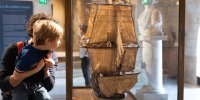 Un enfant et sa mère admirant un modèle de voilier 
